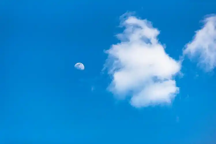 白色的云朵与月亮相伴