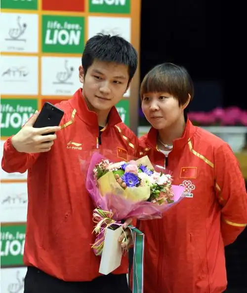 获得男单冠军的樊振东(左)与获得女单冠军的朱雨玲在颁奖仪式后自拍