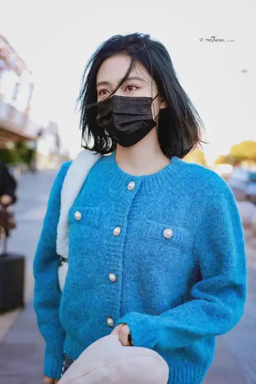 许佳琪今日机场私服分享,蓝色针织开衫搭配爱心钻饰牛仔裤,眉眼精致