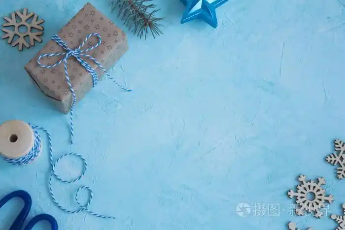 蓝色背景上的圣诞物品.包装圣诞礼物顶部视图