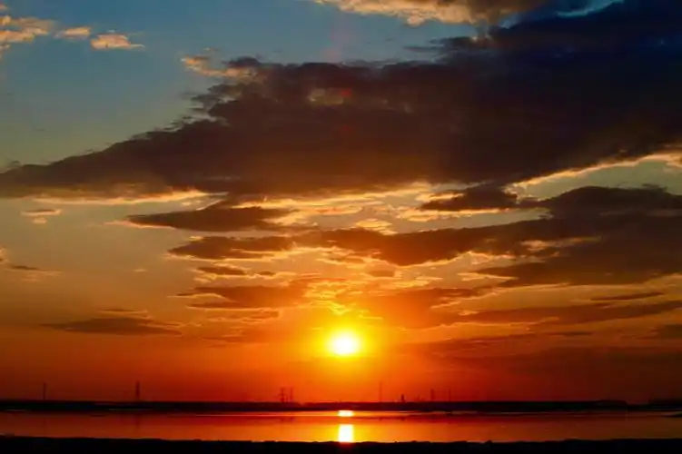 用夕阳的橘红色配上多云的天空,单纯的突显自然之美,盐滩映照着夕阳的