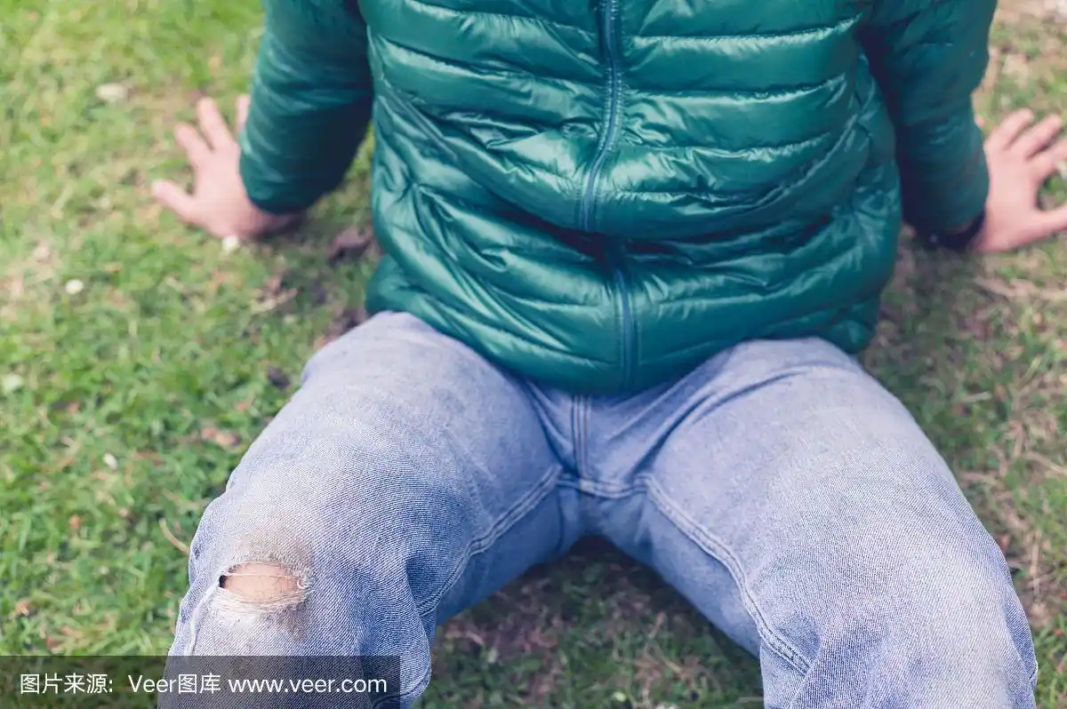 草地上穿着破牛仔裤的男人