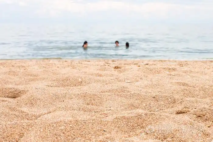 沙滩和模糊的游泳的人在海上