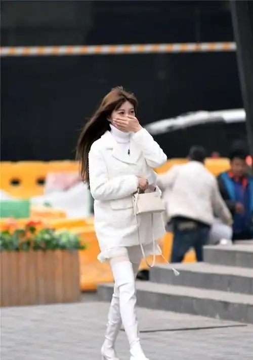 白色粗跟过膝靴搭配白色丝袜毛衣和外套都是白色的