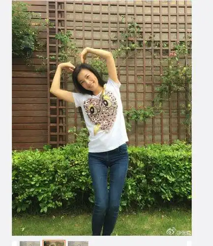 照片中,身着t恤牛仔裤的张庭用双臂摆出心形,甜笑为老公送上祝福.