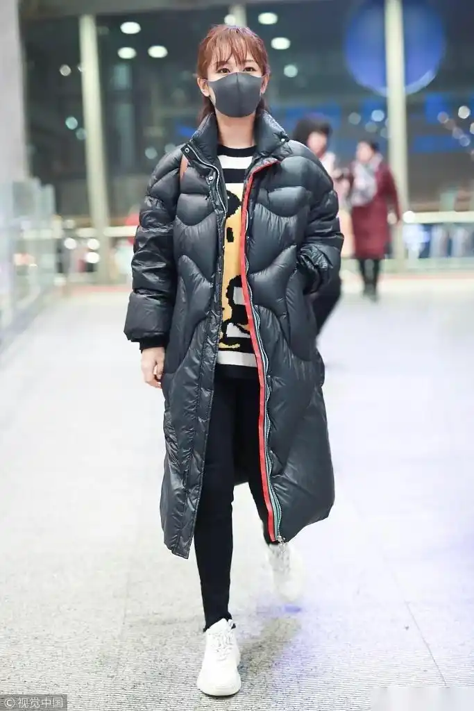 日前,杨紫现身机场,身穿深蓝色"面包服"御寒提前过冬,口罩遮俏脸,颈枕