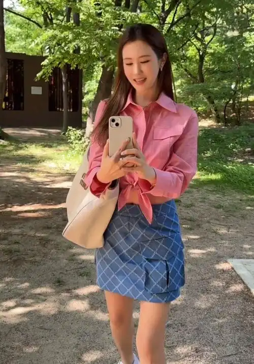 照片中的李多海身穿粉色格子衬衫,搭配牛仔口袋格子迷你裙,展现出清纯