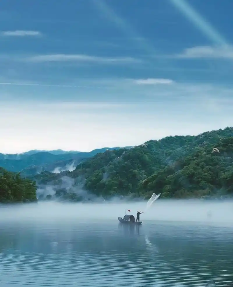 清晨,东江湖的湖面宛如一块平静的明镜,倒映着周围的山峦和树木