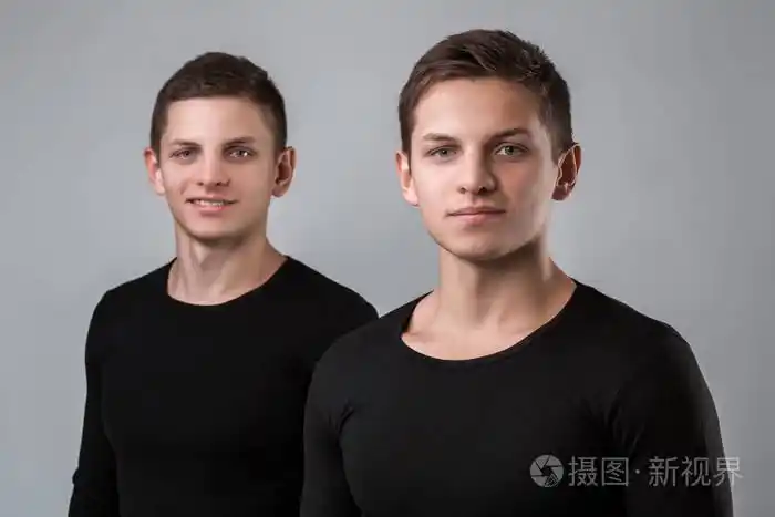 两个双胞胎兄弟站在灰色的背景