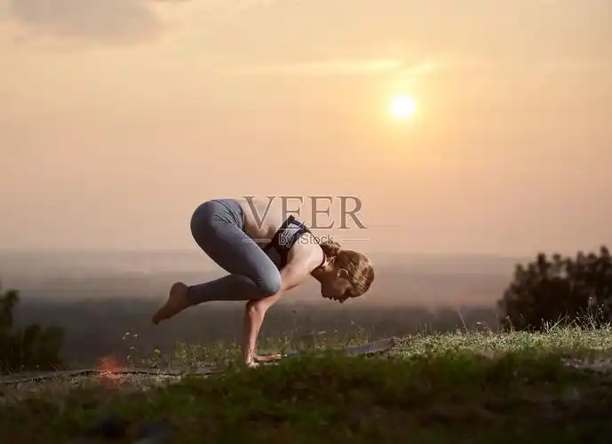 迷人苗条的年轻女子在户外做瑜伽练习在美丽的天空的