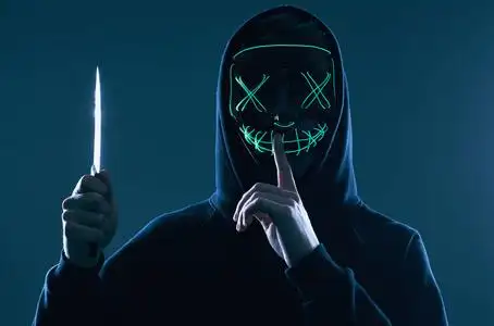 匿名黑客面具程序员使用笔记本电脑在黑暗中入侵系统.