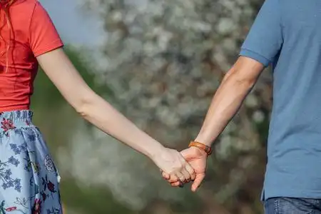 男的纹什么花臂男人和女人在盛开的花园背景下牵手.照片