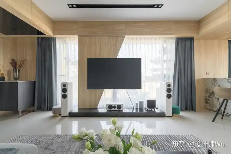 迎面落地采光照亮生动家庭场景,凸显了三面采光优势,并以梯形木色量体