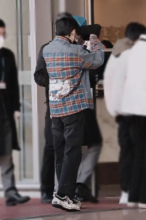 严浩翔今日机场私服分享,牛仔拼接格纹衬衫搭配细微墨点设计牛仔裤