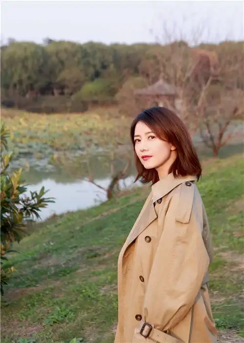 照片中,高圆圆身穿卡其色风衣,妆容精致眼神温柔,阳光映照下更显侧颜