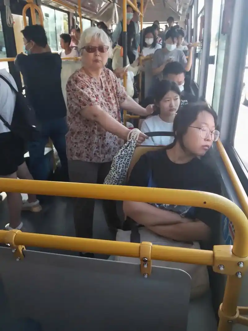 烟台某52路公交车上的一幕,老太太一直站到年轻女孩下车才轮到自己.