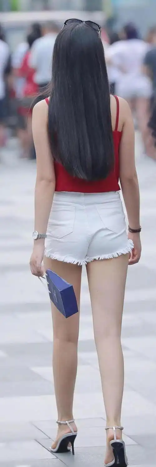 漂亮女孩穿鲜艳的吊带上衣搭配白色短裤显得清新靓丽