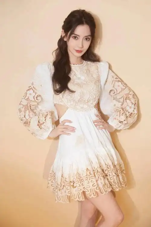 照片中,杨颖穿蕾丝白裙,搭配白色短靴,小波浪卷发,精致的妆容,秀出了