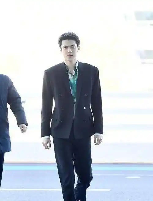 照片里面的吴世勋穿着一件彩色的印花衬衣,绿色拼接白色的衬衣感觉还