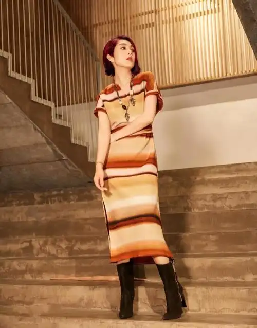 裙子宽松的袖子也显得手臂很细,杨千嬅在脚上穿了一双中筒靴,这一身