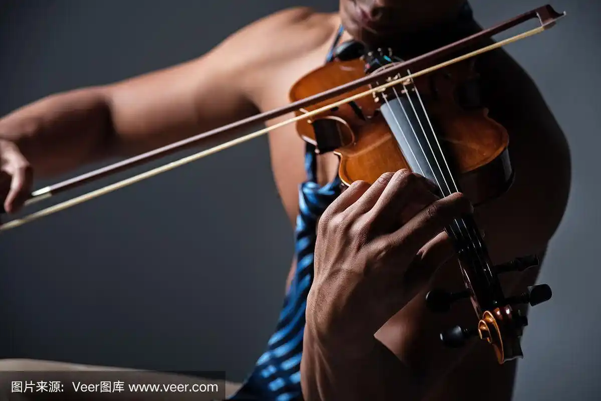 在有选择的焦点的小提琴是由人的手拿着,用弓碰着弦,展示如何演奏的