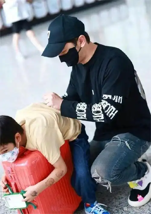 照片中,黄晓明紧紧抱着儿子,两人都穿着红色的亲子服,在一起嬉戏打闹