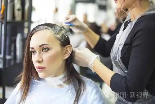 专业女性美发师在设计发廊为女性顾客染发,女性染发.染发染色工艺