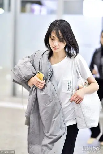 郑爽素颜现身上海机场 穿短袖肩扛棉袄不怕冷