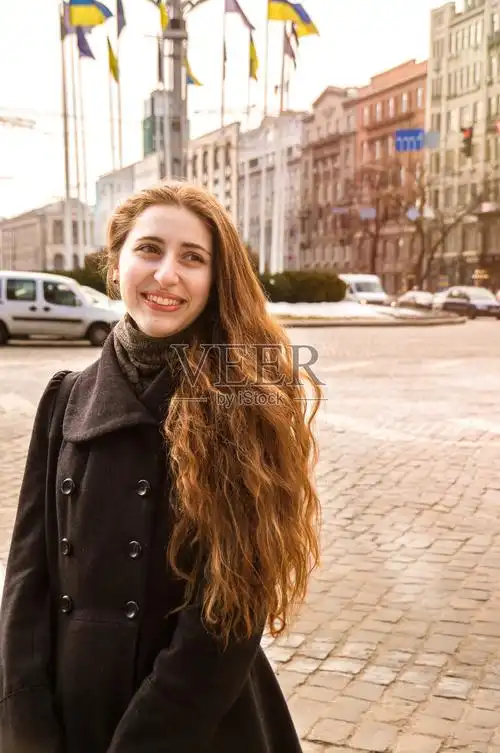 漂亮的快乐的微笑的年轻优雅的女孩走在古老的阳光城市照片摄影图片