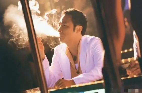 吴镇宇戴着针织帽的影帝张家辉,在街头抽烟被狗仔拍到.