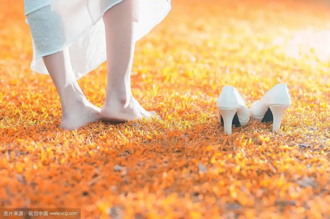 女性赤脚踩在草地上