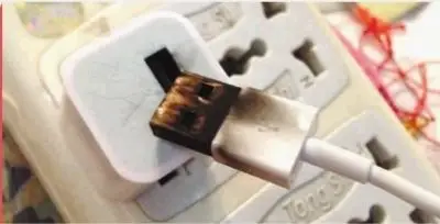 24日晚,张女士为手机充电,充电器突然爆炸.  记者 陈昂 摄