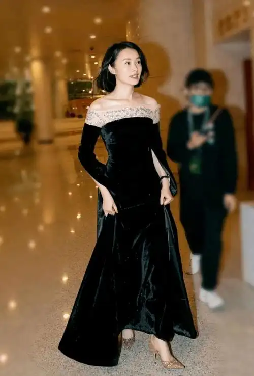 选择的是一字肩的设计,而且是那种丝绒的质地,下面穿的一双高跟鞋,这