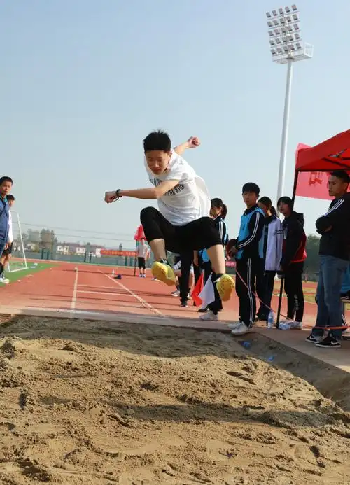 初中组男子跳远运动员奋力一跃,成绩名列前茅.