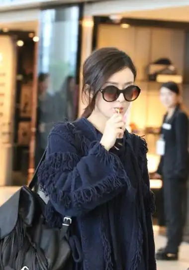 赵丽颖含棒棒糖现身机场心情好微笑任拍