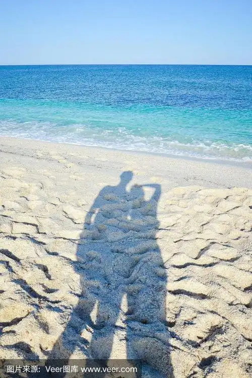 沙滩上一对情侣的影子