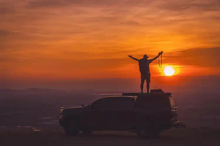 一个人的背影是在思考这个神奇的世界,而他是站在山上对着丛林看.