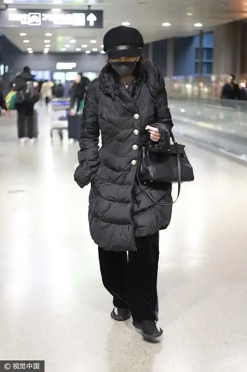 王琳 黑色羽绒大衣金丝绒阔腿裤 头戴报童帽低调简约