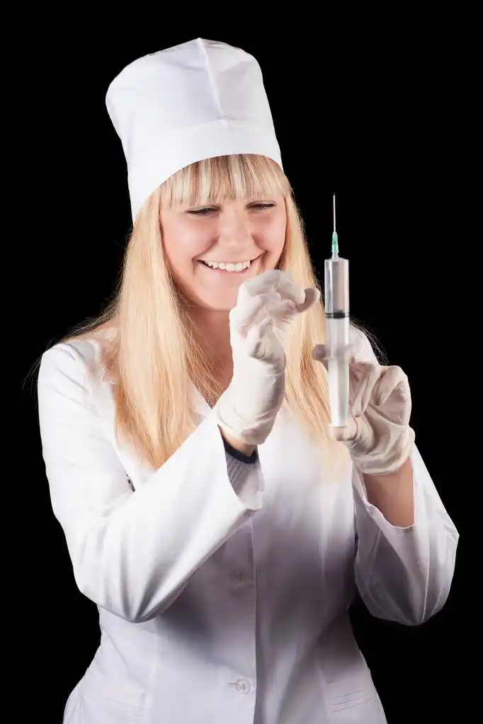 护士,护士举行注射器在黑色背景上的手.