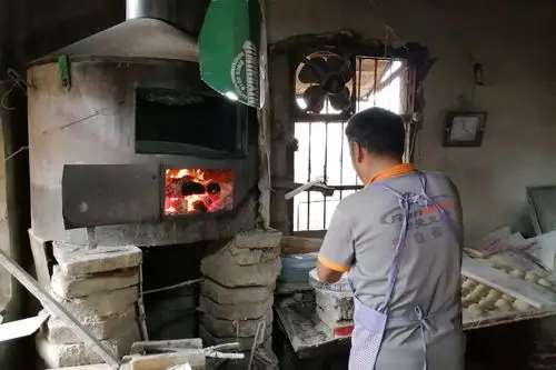 吊炉烧饼,即在吊炉上完成烤制.