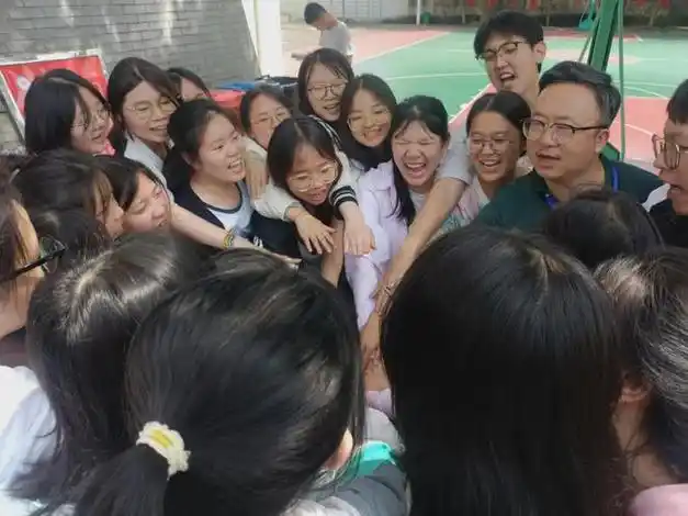 "每个班级的学生先后与校长围成圆圈,手掌一一叠加,圈圈挥舞,呼号声