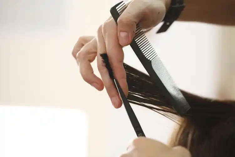 黑色背景下拿理发工具的理发师