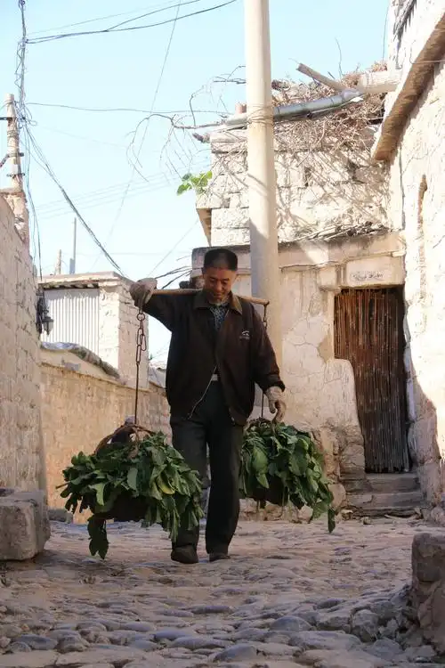 在古朴的街道上一个挑着担子的老人