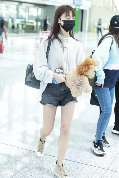 吴谨言穿白卫衣搭配黑色牛仔短裤现身机场抱小熊玩偶少女心满满