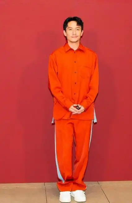 张震用橘色衬衣搭配橘色运动裤,脚踩白色的板鞋,留着英俊的发型,真的