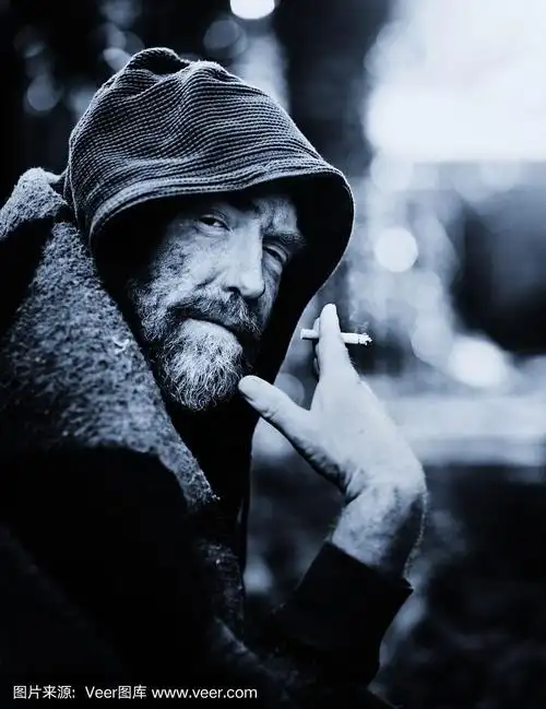 可怜的,邋遢的流浪汉在街上抽烟