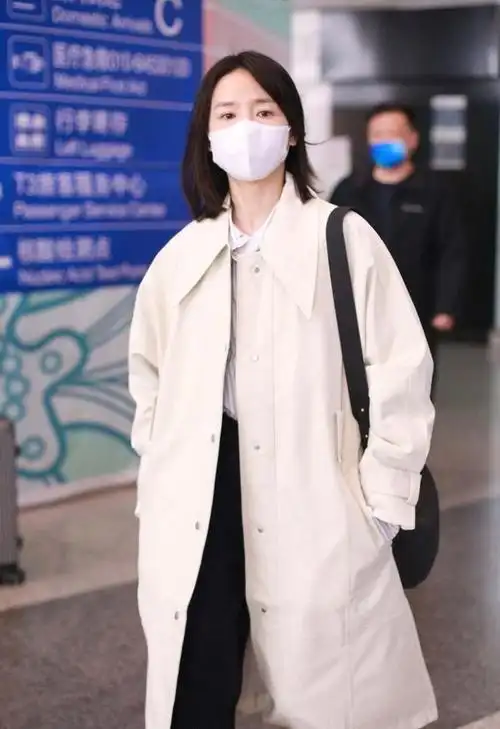 42岁董洁现身机场长款风衣搭阔腿裤时尚舒适显年轻