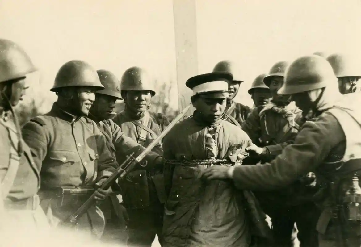 一名士兵被用绳子绑着,他被一群里日本兵包围.