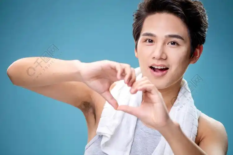 肩膀上搭着毛巾用手比心的年轻男人