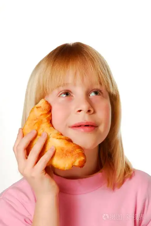 持有和吃牛角面包的小女孩